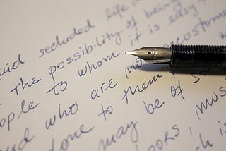 Handwriting, letter on a white page with an ink pen lying atop the letter