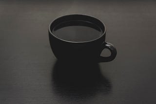 Black coffee placed on top of a quiet table