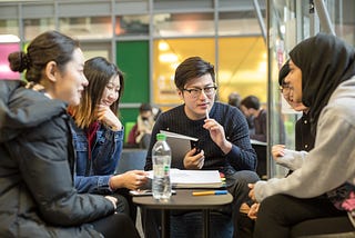 Five students are in deep conversation over their studies