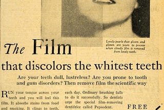 A discoloured old newspaper in Black and White, with a smiling woman’s photo and the title: The Film that discolors the whitest teeth. An opaque rectangle overlapping both the photo and the title.