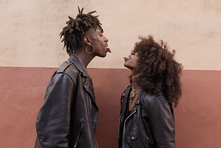 Young Couple Standing Face to Face and Sticking out Tongues