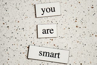 3 blocks on a marble surface saying “you are smart”