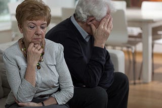 Two older people turning away from each other