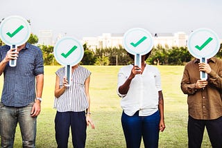 4 people holding, green tick symbol (verified).