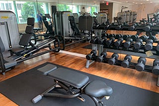 Park Hyatt Washington D.C.’s fitness center, which includes an adjustable bench, a set of dumbbells, and a leg press machine.