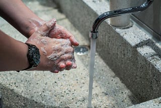 Picture of someone washing their hands, practicing good general hygiene.