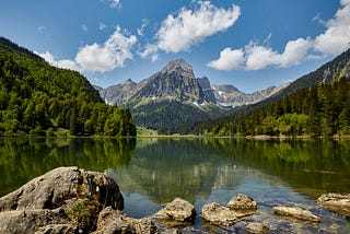 A mountain reflects off the surface of a lake in Switzerland