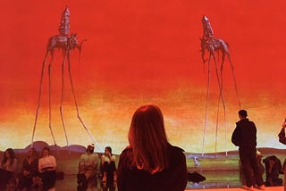 My partner stands silhouetted against an immersive rendering of Dali’s “The Elephants”