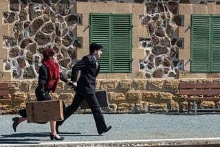Man and woman running with suitcases, vintage look