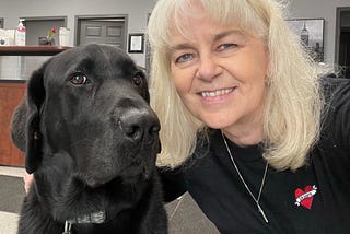 picture of a black lab and a lady with white hair, this is Cooper and Patricia