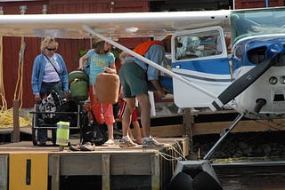 Photo of luggage getting loaded onto a smalll floatplane.