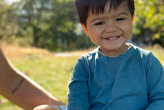 a dad and his smiling son at the park