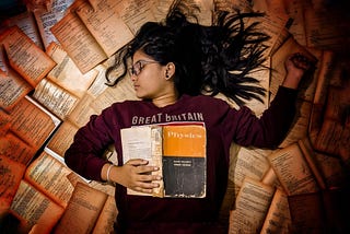 Young student lying on a bed of Physics Books