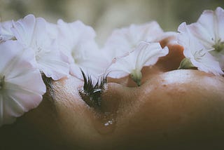 A person cries with flowers on their face.