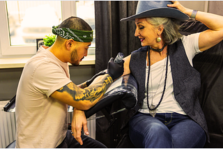 beautiful older woman getting a tattoo