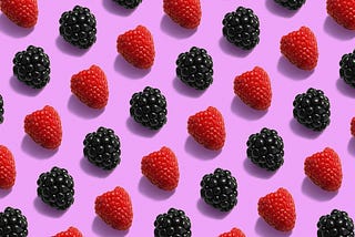 Pictures of red raspberries and blackberries set in rows against a fuchsia background.