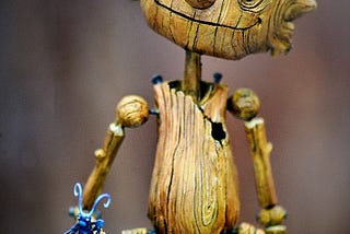 A wooden Pinocchio puppet with a long nose