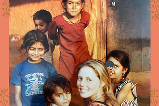 Young woman with blonde hair turns to look at the camera, smiling. She is surrounded by five other children of various ages, mugging for the camera