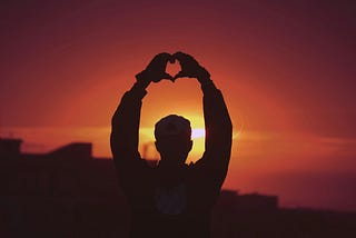 A man making a heart symbol with his hands