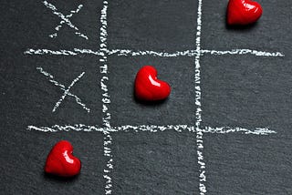 Three red hearts in a game of tic-tac-toe