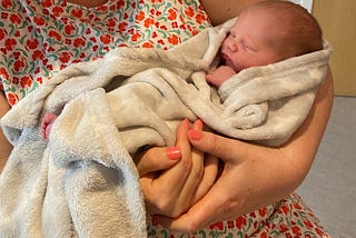 The most perfect baby in the world being held in a blanket, snoozing