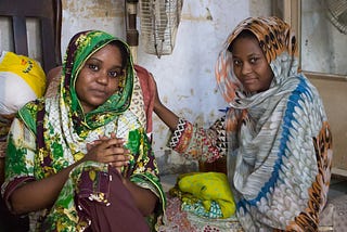 Hina Yaqoob and her cousin sitting in their home.