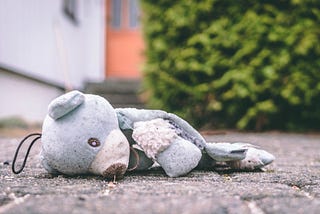Teddy alone and neglected on pavement