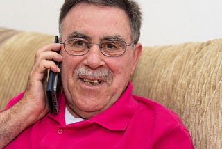 senior man happily talking on the phone — staying connected safely