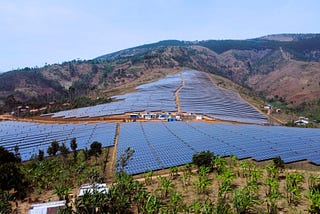 A large solar plant with thousands of panels installed on a hill.