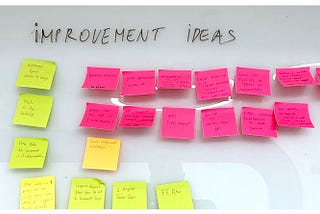 Improvement ideas written on sticky notes are listed on a white dashboard