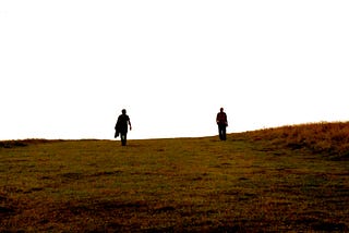 Photo showing the silhoutte of two men.