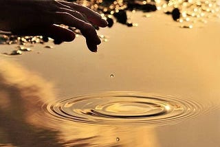 Reflection of hand on water body