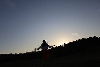 silhouette of girl spinning in nature