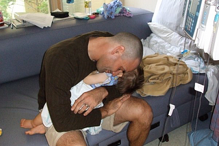 Man holding babyson in hospital