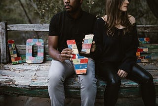 Separated couple holding a broken ‘V’ from a LOVE sign