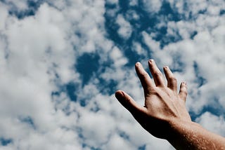 Hand reaching for the clouds.