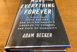 Photo of the book “More Everything Forever: AI Overlords, Space Empires, and Silicon Valley’s Crusade to Control the Fate of Humanity,” by Adam Becker, the letters of which appear to be traveling at light speed through space. (Photo by author.)