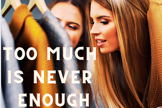 a blond woman with her face between clothing — caption “too much is never enough”