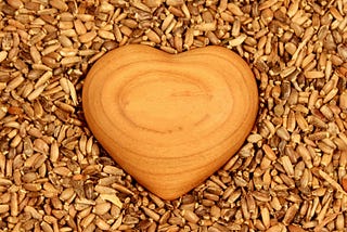 Wooden heart on seeds, showing love and kindness to everyone we meet