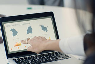 A woman pointing at a dataviz on a laptop
