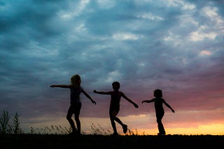 Children walking in a line at sunset. This symbolises the mind and body moving in relation to each other.