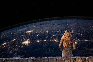 A girl sitting alone staring a sparkling planet.