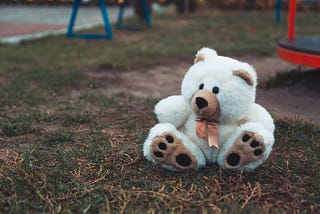 Teddy bear abandoned on a play ground