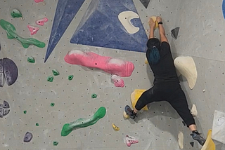 author climbing a rock wall at the gym