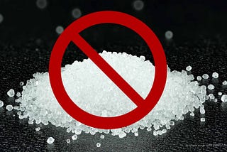 A small pile of white crystalized fructose with a red circle and diagonal line over top.