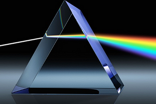Picture of a rainbow shining through a prism against a black background.