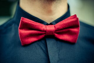 Red bow tie with black shirt closeup