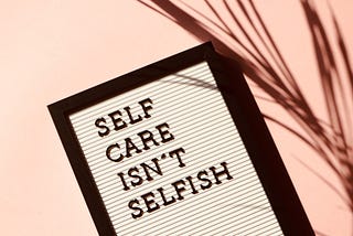A sign that says, “Self Care Isn’t Selfish”