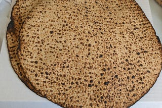 Two handmade shmurah matzot on top of the box they came in