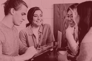 Four people standing around a table, smiling